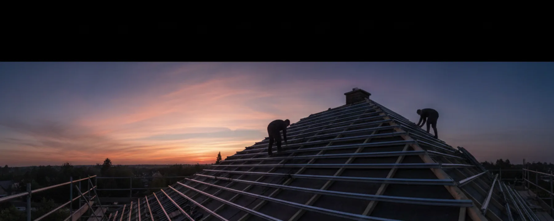 Baustelle mit Gerüst und Arbeitern bei der Montage einer Solaranlage